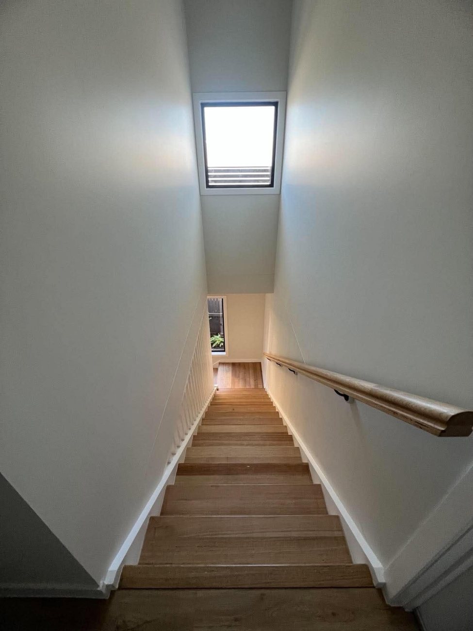 Timber staircase with handrail and skylight window