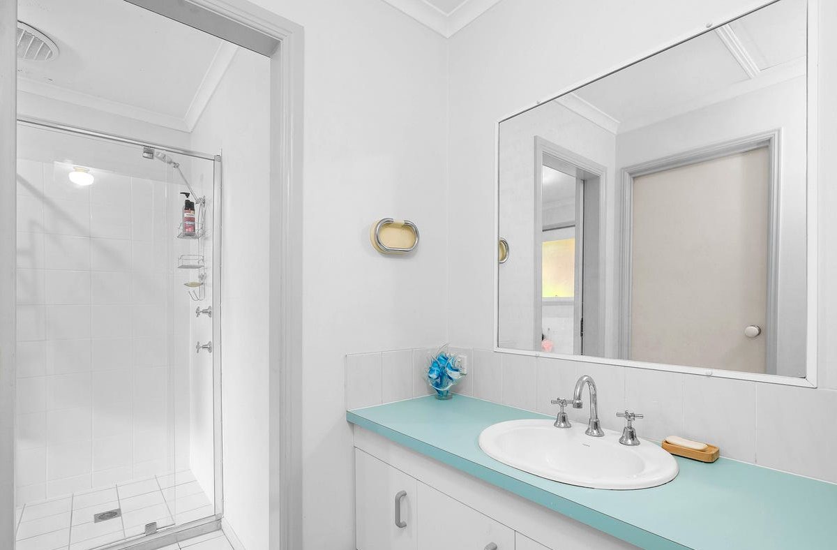 Bathroom before: teal laminate vanity top and dated fittings