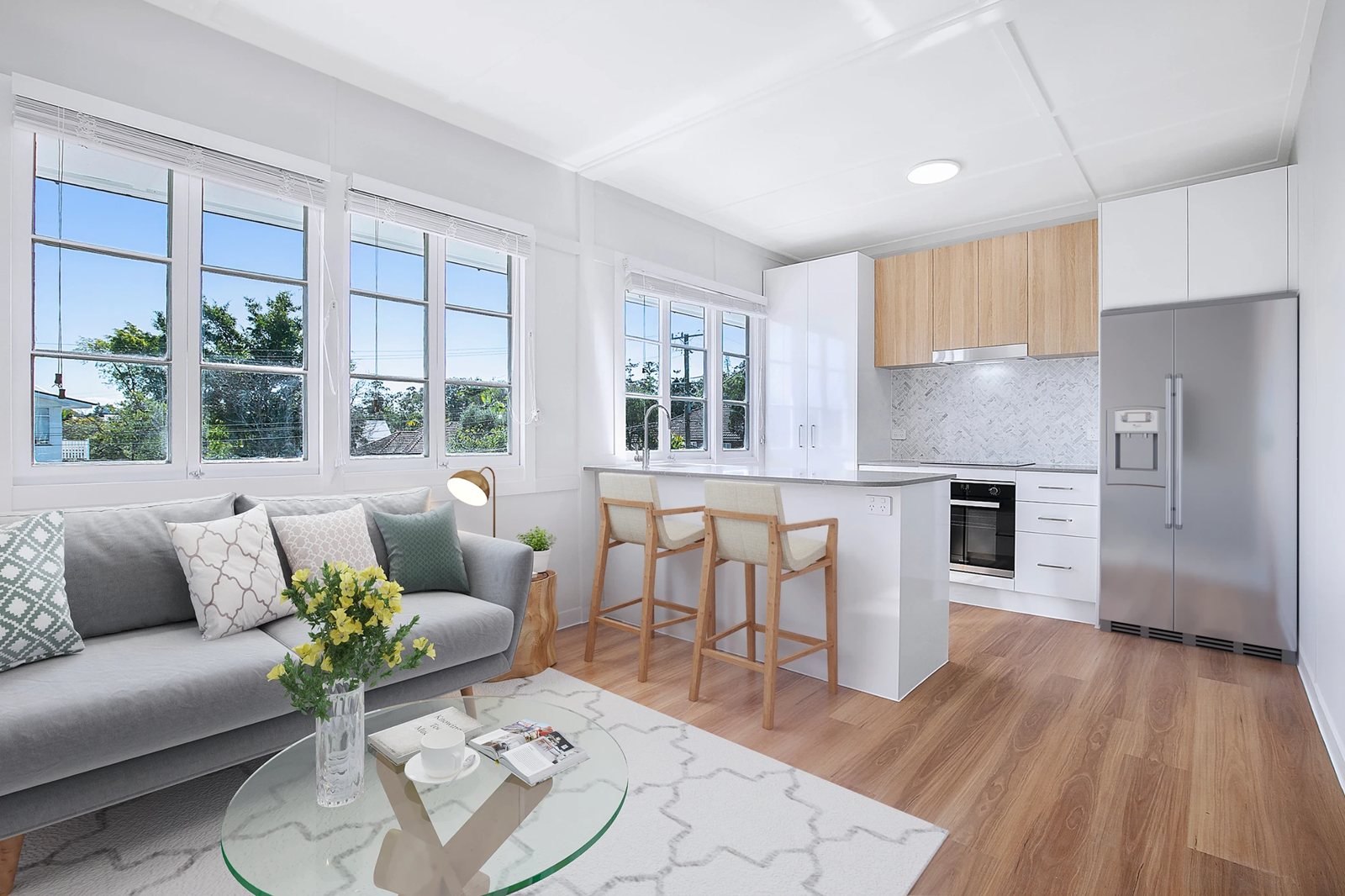 Open-plan kitchen and living with casement windows and timber-look floors